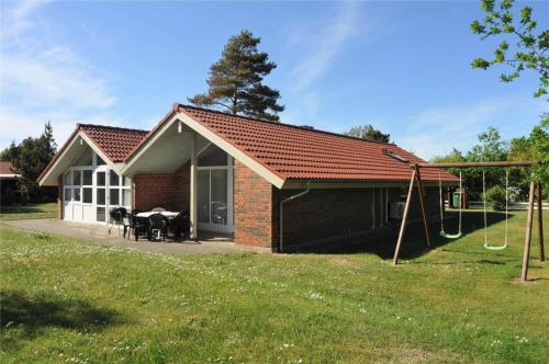 a small house with a picnic table and a swing at 30705-Ulfborg-Valmuevej-288 in Vang