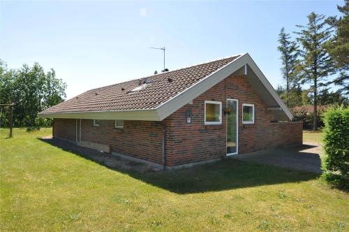 a small brick house in a field of grass at 30705-Ulfborg-Valmuevej-288 in Vang