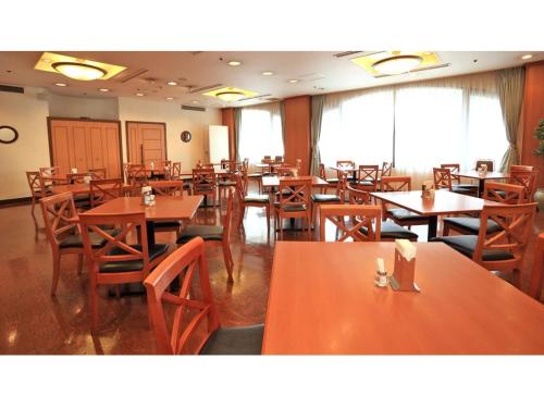 a dining room with wooden tables and chairs at Smile Hotel Shimonoseki - Vacation STAY 12586v in Shimonoseki