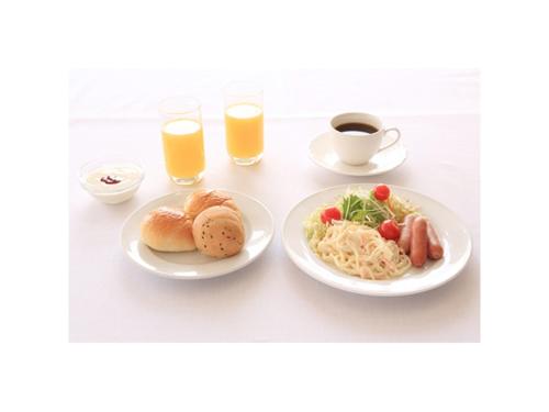 a table with two plates of food and glasses of orange juice at Smile Hotel Shimonoseki - Vacation STAY 12507v in Shimonoseki