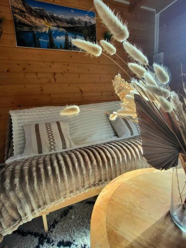 a bed in a room with a table at Chalet cosy & jacuzzi privé - Paris & Disney in Ormesson-sur-Marne