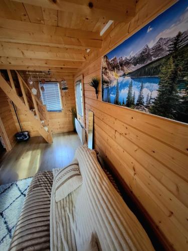a bedroom of a log cabin with a large picture on the wall at Chalet cosy & jacuzzi privé - Paris & Disney in Ormesson-sur-Marne