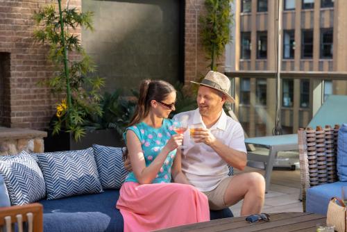a man and a woman sitting on a couch with drinks at Margaritaville Resort Times Square in New York