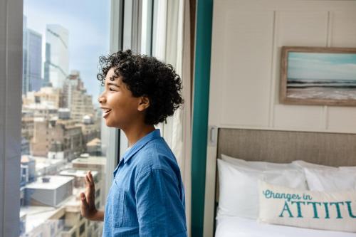 a woman looking out a window in a hotel room at Margaritaville Resort Times Square in New York