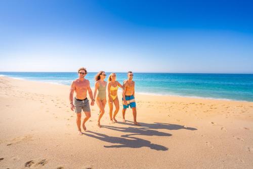 a group of people walking on the beach at Sandos Finisterra All Inclusive in Cabo San Lucas