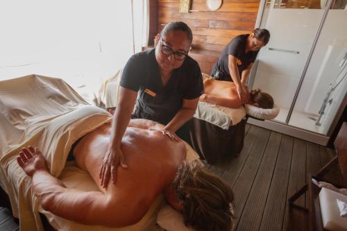 a woman getting a mans backidated by a masseur at Sandos Finisterra All Inclusive in Cabo San Lucas