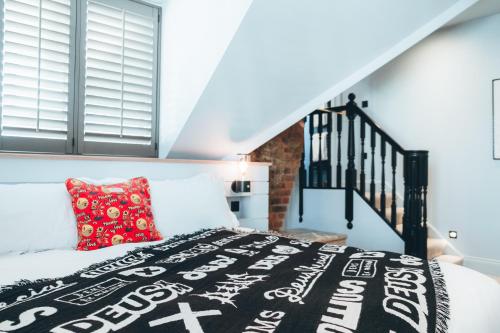 a bedroom with a bed with a black and white comforter at Deus Ex Machina Hotel in Bournemouth