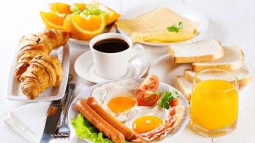 a breakfast table with eggs and bread and a cup of coffee at flower land in Kutaisi