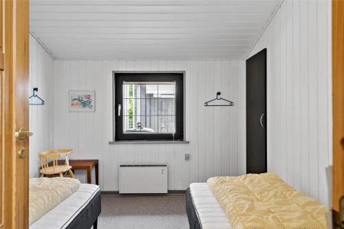 een slaapkamer met twee bedden en een raam bij 30370-Ulfborg-Lathyrusvej-314 in Vang