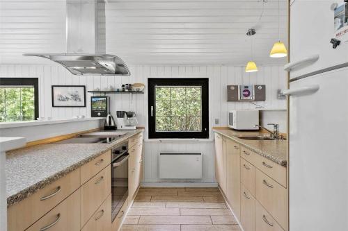 een keuken met witte muren en houten kasten bij 30370-Ulfborg-Lathyrusvej-314 in Vang