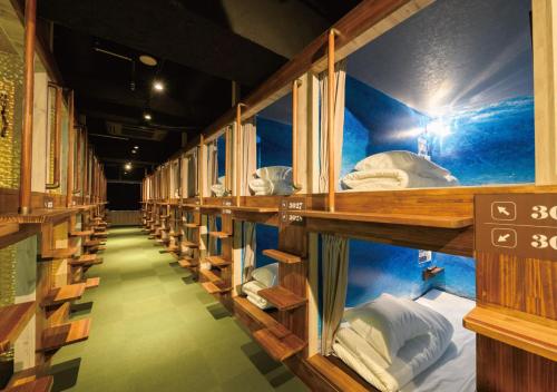 a row of shelves in a room filled with beds at The Centurion Sauna Rest & Stay Sapporo Male Only in Sapporo
