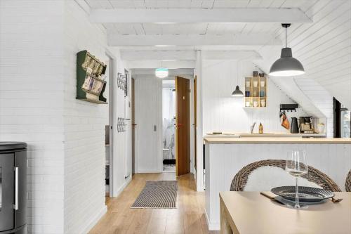 a kitchen and dining room with white walls and a table at 20356-Ulfborg-Lars-Murersvej-9 in Vedersø Klit