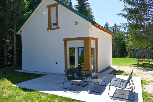 a group of chairs and a table in front of a building at Mountain Majesty in Žabljak