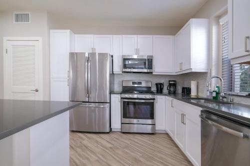 a kitchen with white cabinets and stainless steel appliances at Multiple Miracle Mile Apartments Hub in Los Angeles