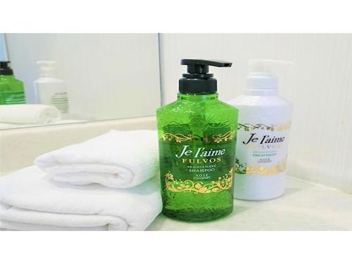 a bathroom with a bottle of hand soap and towels at Smile Hotel Kobe Motomachi - Vacation STAY 05041v in Kobe