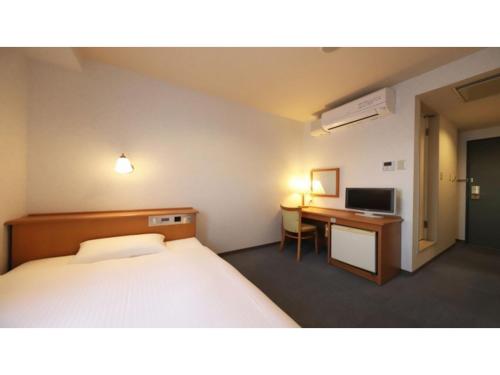 a room with a bed and a desk with a computer at Smile Hotel Takaoka Ekimae - Vacation STAY 89663v in Takaoka
