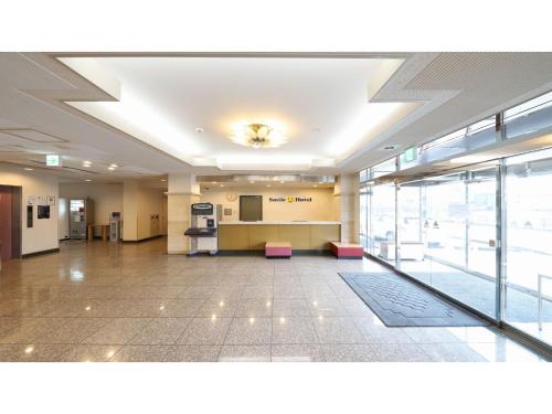 an empty lobby with pink chairs in a building at Smile Hotel Takaoka Ekimae - Vacation STAY 89663v in Takaoka