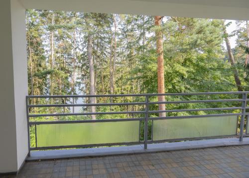 a balcony with a green fence and trees at Vilas & Wellness Resort Orlík in KozÃ¡rovice