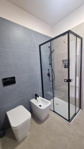 a bathroom with a shower and a toilet and a sink at CB Apartments in Bonito