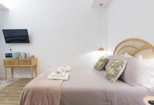 a bedroom with a large white bed with white pillows at The Quarters in Cagliari