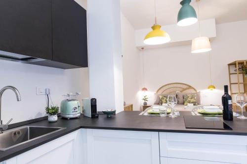 a kitchen with white cabinets and a black counter top at The Quarters in Cagliari