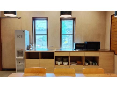 a kitchen with a counter with two chairs and a refrigerator at DIG the Osaka - Vacation STAY 14539v in Suita
