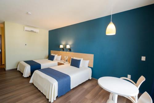 a hotel room with two beds and a table at Oceano Palace in Mazatlán