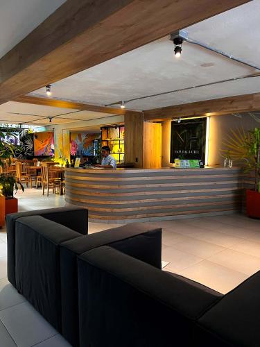 a bar in a restaurant with a person in the background at Hotel Natural Medellin in Medellín