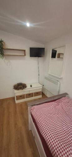 a bedroom with a bed and a tv on the wall at STUGA bei GRETA in Marl