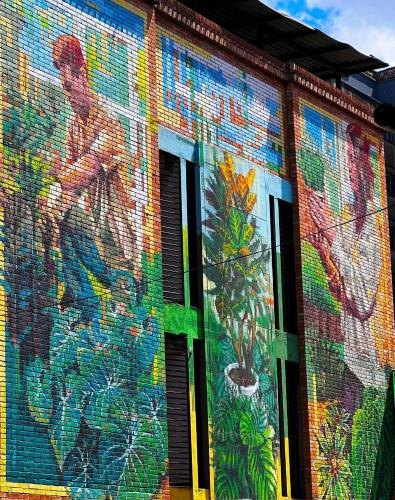 a mural on the side of a building with windows at Hotel Natural Medellin in Medellín