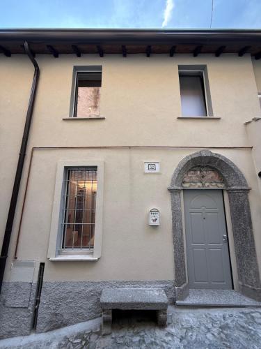 a building with a door and two windows and a bench at DN ART ROYALE - APT N vasca idromassaggio interno piano terra -APT D esclusivo terrazzo esterno con jacuzzi in Blevio