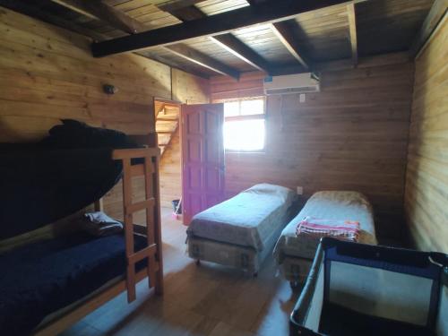 マル・デル・プラタにあるCabañas Yarriのベッド2台とテレビが備わるキャビンです。