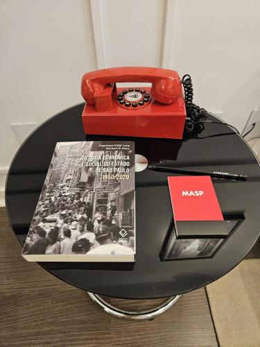a table with a magazine and a telephone on it at EstanPlaza Nações Unidas - SP Classic - apto 302 in Sao Paulo