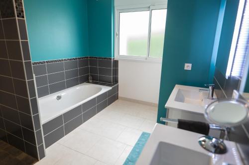 a bathroom with a bath tub and a sink at Chambres d'hôtes proche du Golfe avec petit-déjeuner in Saint-Armel