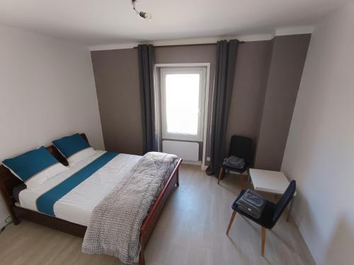 a bedroom with a large bed and a window at Aux lits de la loire in Champtoceaux