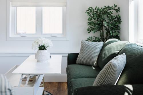 a living room with a green couch and a table at Brass Apple Cottage in Campbell River