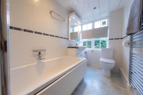 a white bathroom with a tub and a toilet at Meadowcroft in Lindale