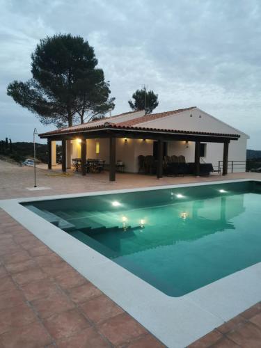a swimming pool in front of a house at Casa Clarita hasta 21 personas, piscina a 40 min de Madrid y aeropuerto in Perales de Tajuña