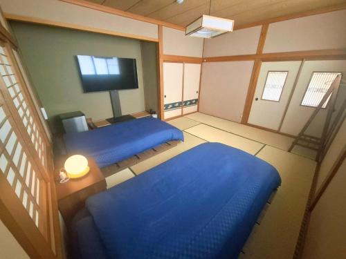 a bedroom with two blue beds and a television at Sado - House - Vacation STAY 20051 in Sado