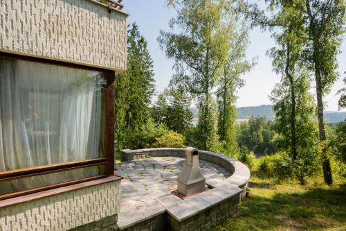 a stone patio with a fireplace next to a window at Vilas & Wellness Resort Orlík in KozÃ¡rovice