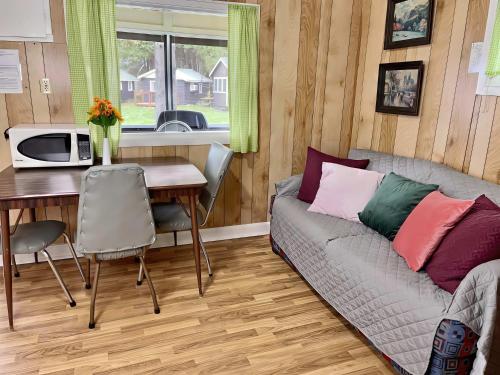 una sala de estar con un sofá y una mesa en Ambleside - 2-Bedroom Cottage #5, en Kawartha Lakes