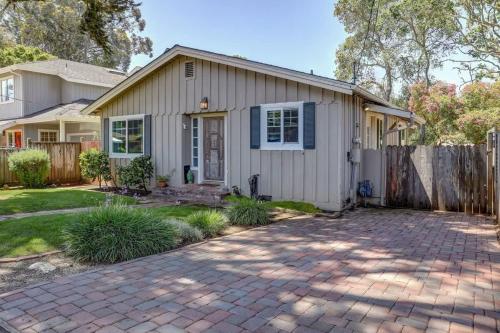 ein Haus mit einem Zaun und einer steinernen Einfahrt in der Unterkunft Spruce Beach Cottage - Walk to beach in Aptos