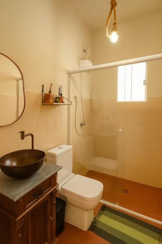 a bathroom with a toilet and a sink and a shower at Chalé Roberta in Holambra