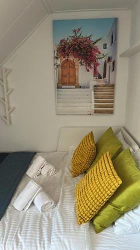 a bed with two yellow pillows and a picture of a door at Eastern in Tilburg