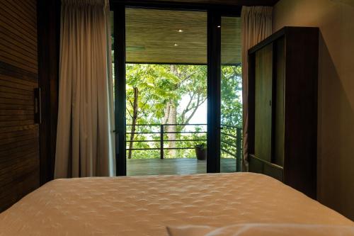 a bedroom with a bed and a large window at Casa VISTA PARAISO in Santa Teresa Beach