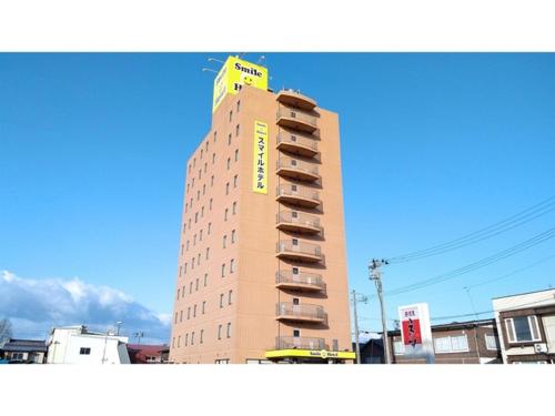 a tall building with a yellow sign on top of it at Smile Hotel Towada - Vacation STAY 06123v in Towada
