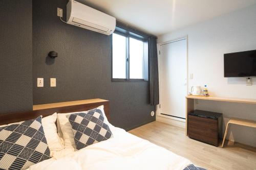 Un dormitorio con una cama y una ventana y un televisor. en Tokyo Biyori Hotel - Vacation STAY 07393v, en Tokio