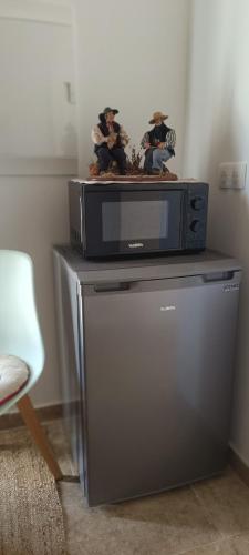 two figurines sitting on top of a microwave at Au Romarin in Cavaillon