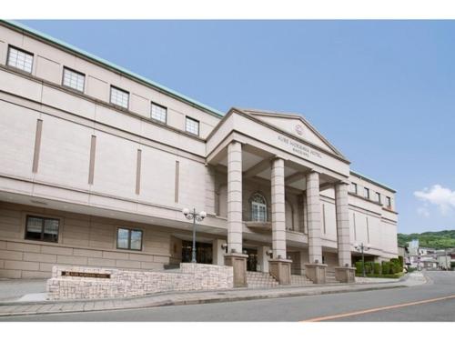 a large white building with columns on a street at K,M,H Art hotel by Kure Morisawa - Vacation STAY 23309v in Kure