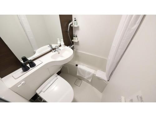 ein weißes Badezimmer mit Toilette und Waschbecken in der Unterkunft Smile Hotel Kanazawa Nishiguchi Ekimae - Vacation STAY 11469v in Kanazawa